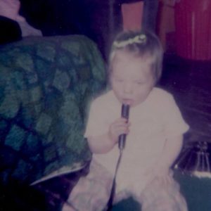 Baby Dawn singing into a microphone.